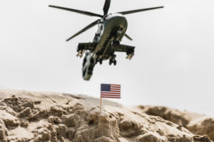 A military helicopter in the sky.